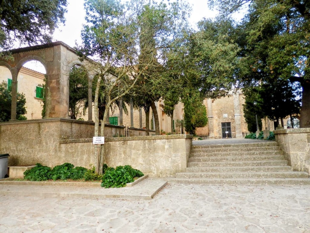 Vista del Santuario de Cura en Puig de Randa, con escaleras de piedra y vegetación alrededor.