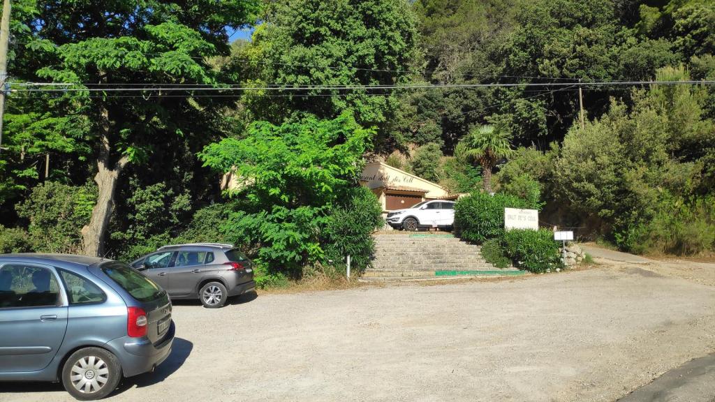 Vista del aparcamiento y el restaurante Dalt d’es Coll, rodeado de vegetación en la Ruta Antenas d’Alfàbia.