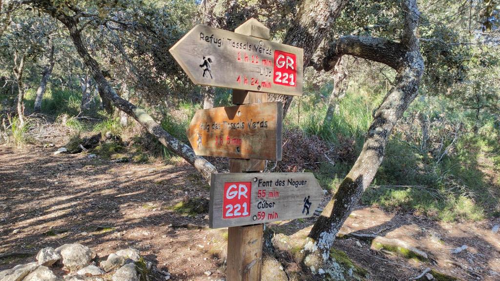 Cartel indicativo de rutas en la senda hacia el Refugio de Tossals Verds, señalizando tiempos de recorrido hacia diversos destinos en la ruta 'Puig de Massanella'.