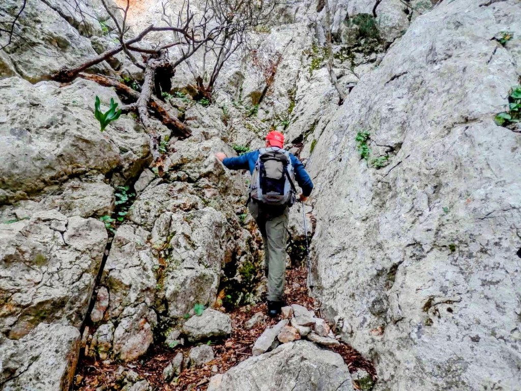 Senderista ascendiendo por el Pas del Ganxo en la ruta 'El Morro de la Bombarda y El Puig de los Boixos'.