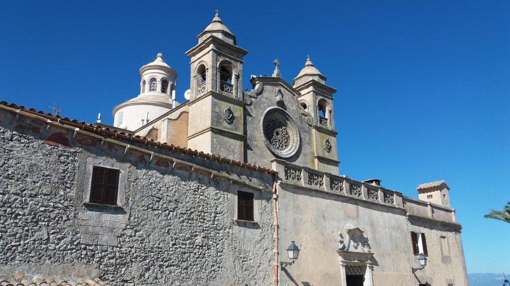 Vista de la Ermita de Bonany, una iglesia con cúpulas y torres campanario, situada en un entorno claro y soleado con un cielo azul despejado.