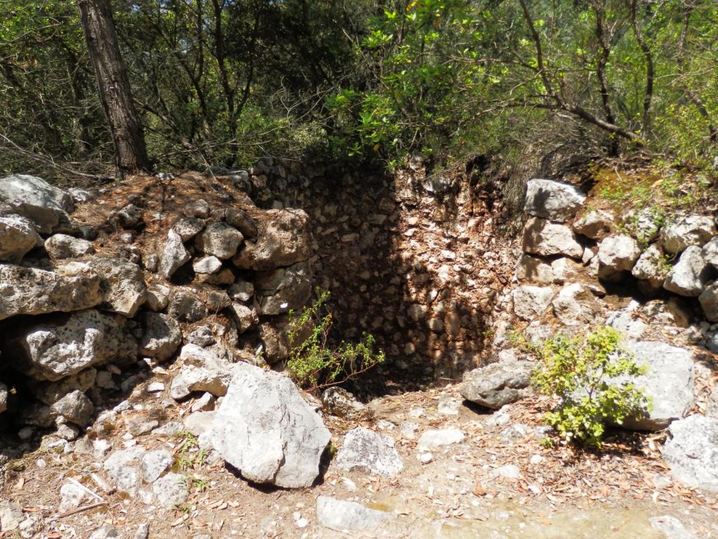 Restos de un horno de cal en un entorno natural, rodeado de rocas y vegetación, en la ruta 'Ses Figueroles y Alcanella'.