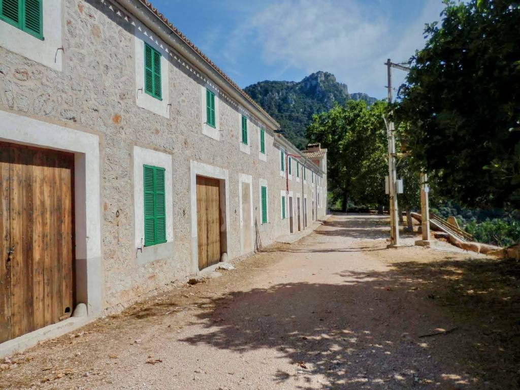 Vista de las Casas de Planicia, rodeada de vegetación y montañas al fondo.