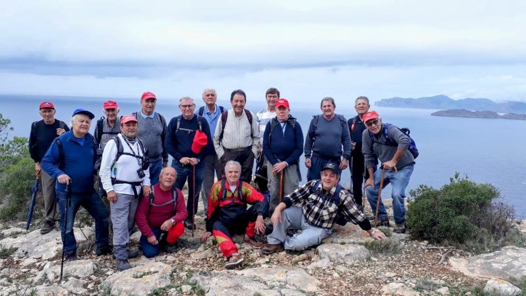Grupo de personas durante una excursión en la Ruta El Toro, posando en un acantilado con vistas al mar.