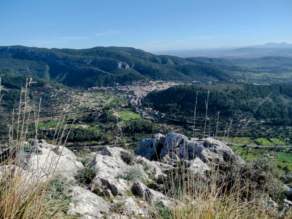 Vista panorámica desde la cima del Puig de Son Nassi, mostrando montañas y valles con cultivo, bajo un cielo despejado.