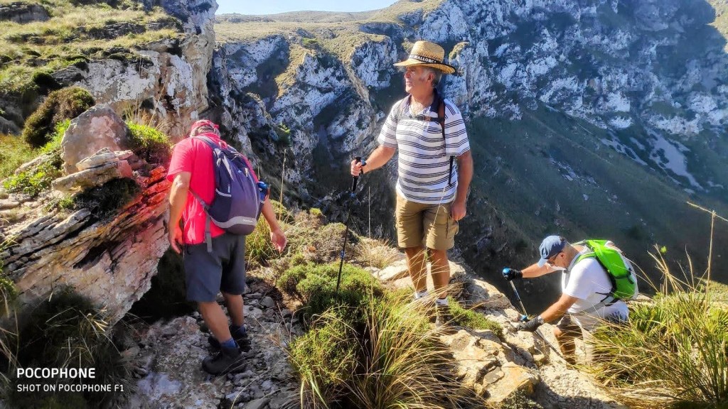 Grupo de excursionistas en el Pas des Porc, con vistas rocosas y verdes mientras realizan una ruta en el Parque Natural de la Península de Levante.
