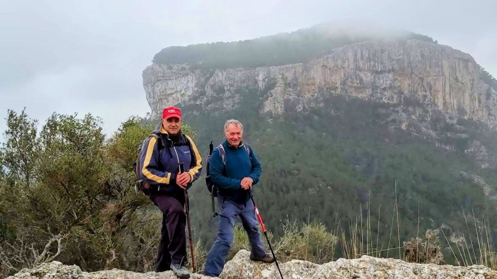 Dos hombres con bastones de senderismo posando en el Puig de Sant Miquel.