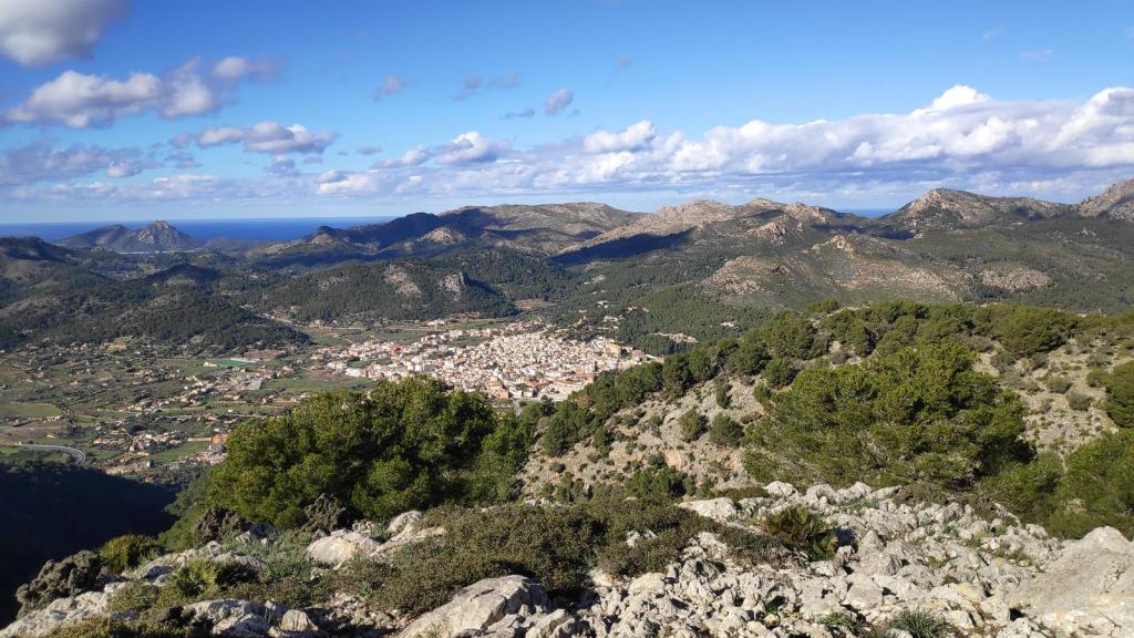 Panorámica desde el Puig de Garrafa, mostrando el pueblo de Andratx y la costa mallorquina con montañas y cielo despejado.