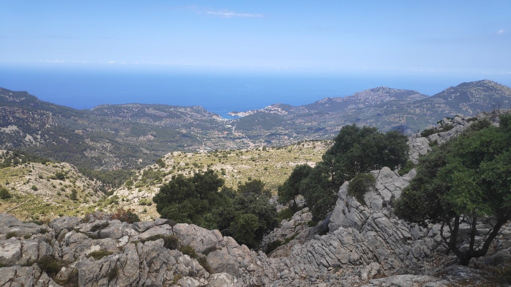 Vista panorámica desde la cima del Puig d'Alfàbia, mostrando montañas y el mar al fondo.
