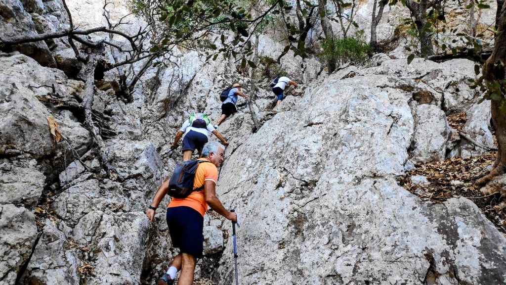 Grupo de excursionistas ascendiendo por el Pas del Ganxo en la ruta Morro de la Bombarda-Puig de los Boixos.