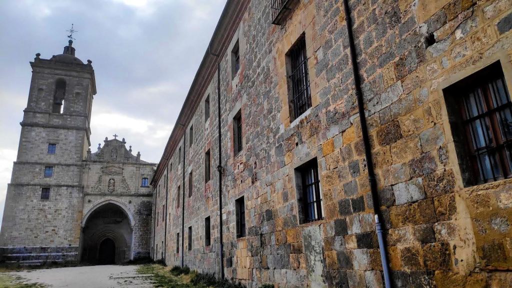 Vista del Monasterio de Irache con su fachada de piedra, torres y un camino de acceso.