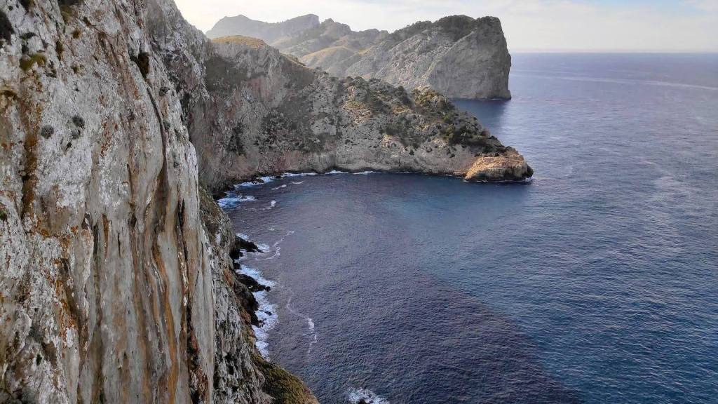 Vista panorámica de acantilados y costa en la Península de Formentor, con aguas turquesas y un fondo montañoso.