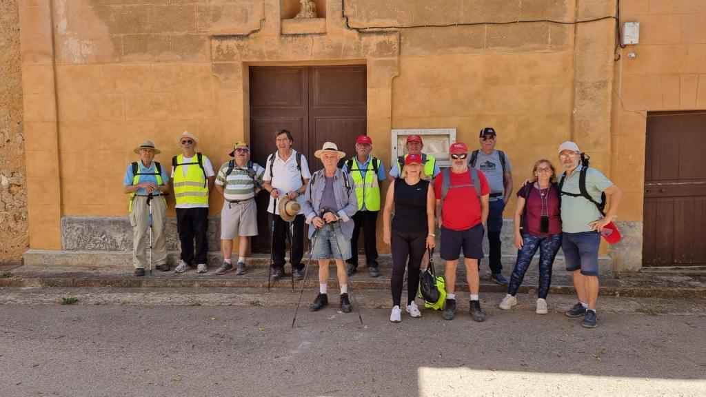 Grupo de personas posando frente a un edificio de color ocre, en Son Negre