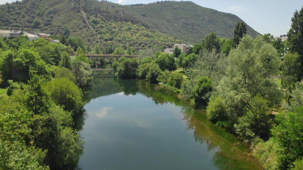 Vista del río Sil rodeado de vegetación y montañas en el paisaje de Ponferrada, España.