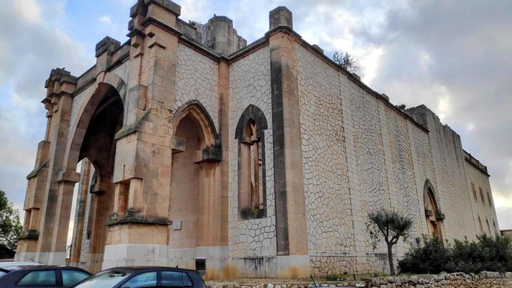 Iglesia en estado de ruina en Biniamar, mostrando arcos de piedra y una estructura inacabada.