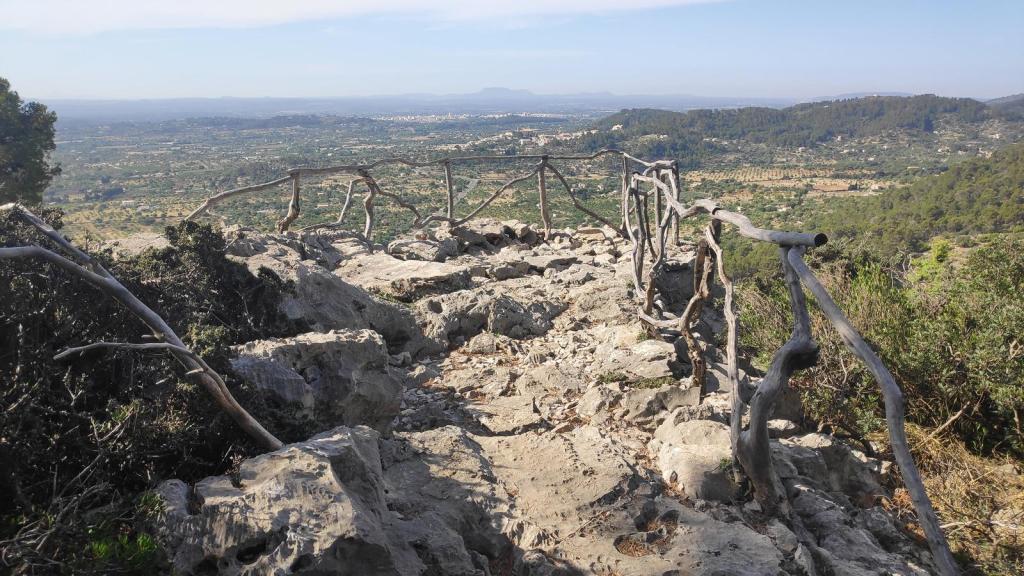 Vista desde el “Mirador de la quarta volta”, con barandilla de madera, mostrando un paisaje montañoso y valles en el fondo.