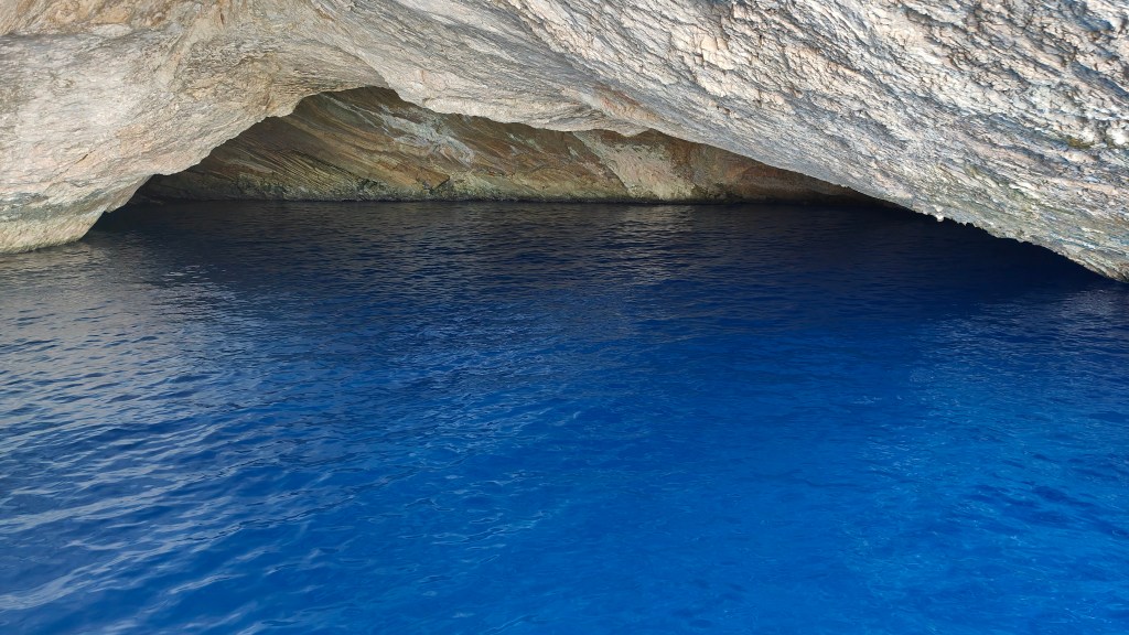 Vista del interior de la Cueva Azul en Cabrera, con aguas de un intenso color azul y formaciones rocosas en la parte superior.