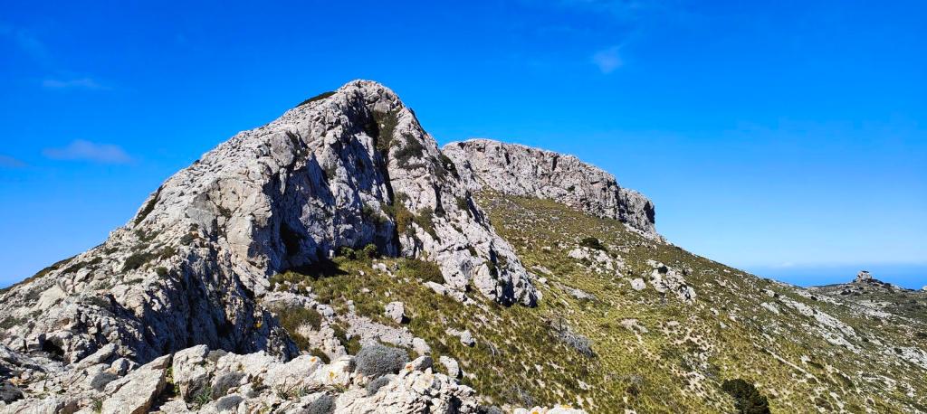 Puig Batiat-Cadira del Bisbe-Es Moletó - Caminando por Mallorca Vista panorámica de las cimas rocosas de la ruta "Puig Batiat-Cadira del Bisbe-Es Moletó" bajo un cielo azul despejado.
