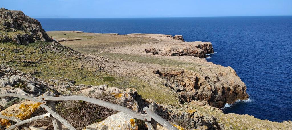 Vista panorámica desde el Mirador de Sa Falconera, con costas rocosas y un mar azul profundo en el fondo.