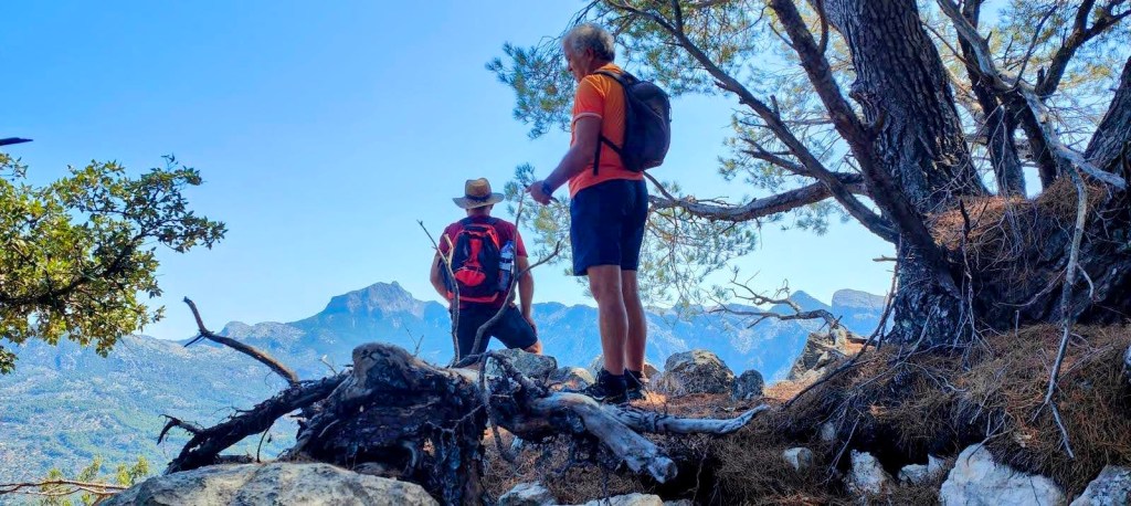 Dos senderistas admirando el paisaje montañoso desde el mirador del Penyal de Rocafort