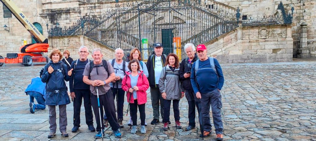 Grupo de personas posando en la Plaza del Obradoiro, Santiago de Compostela, con la Catedral al fondo.