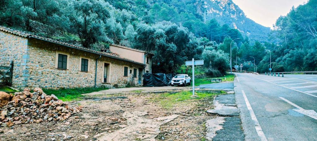 Vista del inicio de la ruta 'Puig del Moro desde el túnel de Sóller', mostrando una caseta de piedra junto a una carretera en un entorno montañoso.