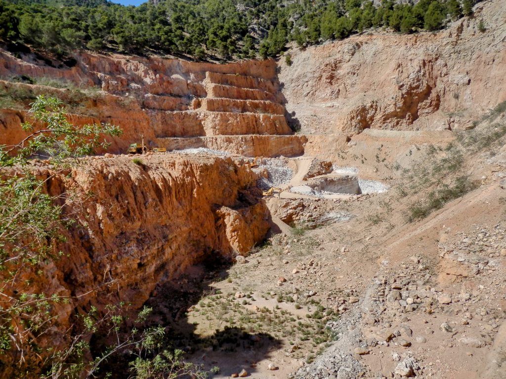 Canteras de Na Dalmau, mostrando un paisaje de extracción de minerales con capas de roca expuestas y maquinaria en uso.