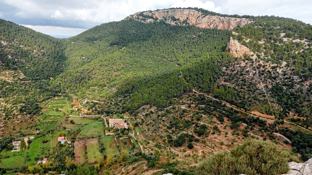 Panorámica desde la montaña Moleta de Son Cabaspre y el valle circundante, con vegetación densa y caminos visibles en la ladera.