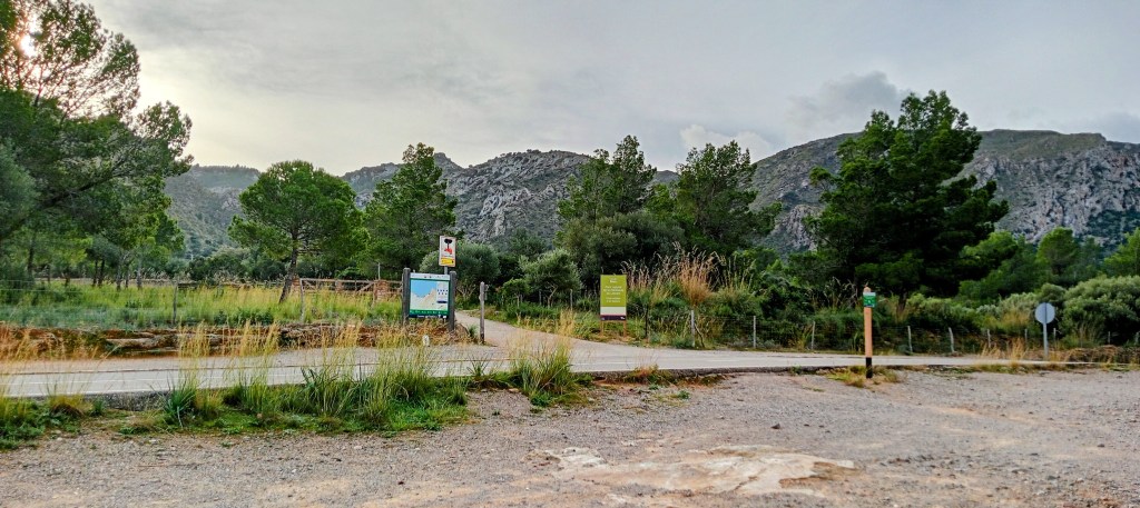 Entrada al camino de la ruta Bec de Ferrutx, con señalización en el inicio y vistas de la sierra al fondo.