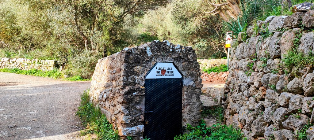 Sa Font de ses Artigues en un entorno natural, rodeada de vegetación y un camino de tierra.