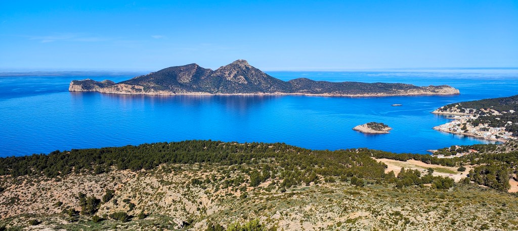 Vista panorámica de Sa Dragonera rodeada de un mar azul con un cielo despejado.