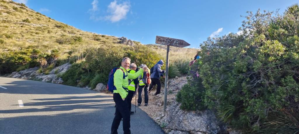 Grupo de personas en una ruta de senderismo junto a un letrero que indica 'Camí del Caló'.